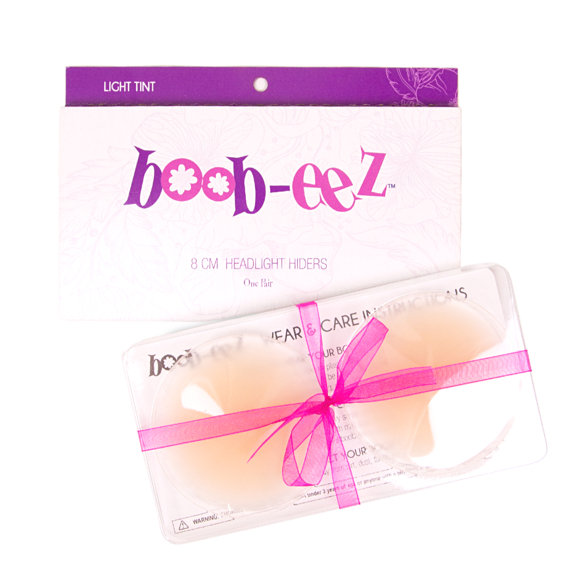 Product shot of reusable 8cm Light tint Headlight Hiders in recycled craft packaging and information insert card with wear and care instructions, against a white background