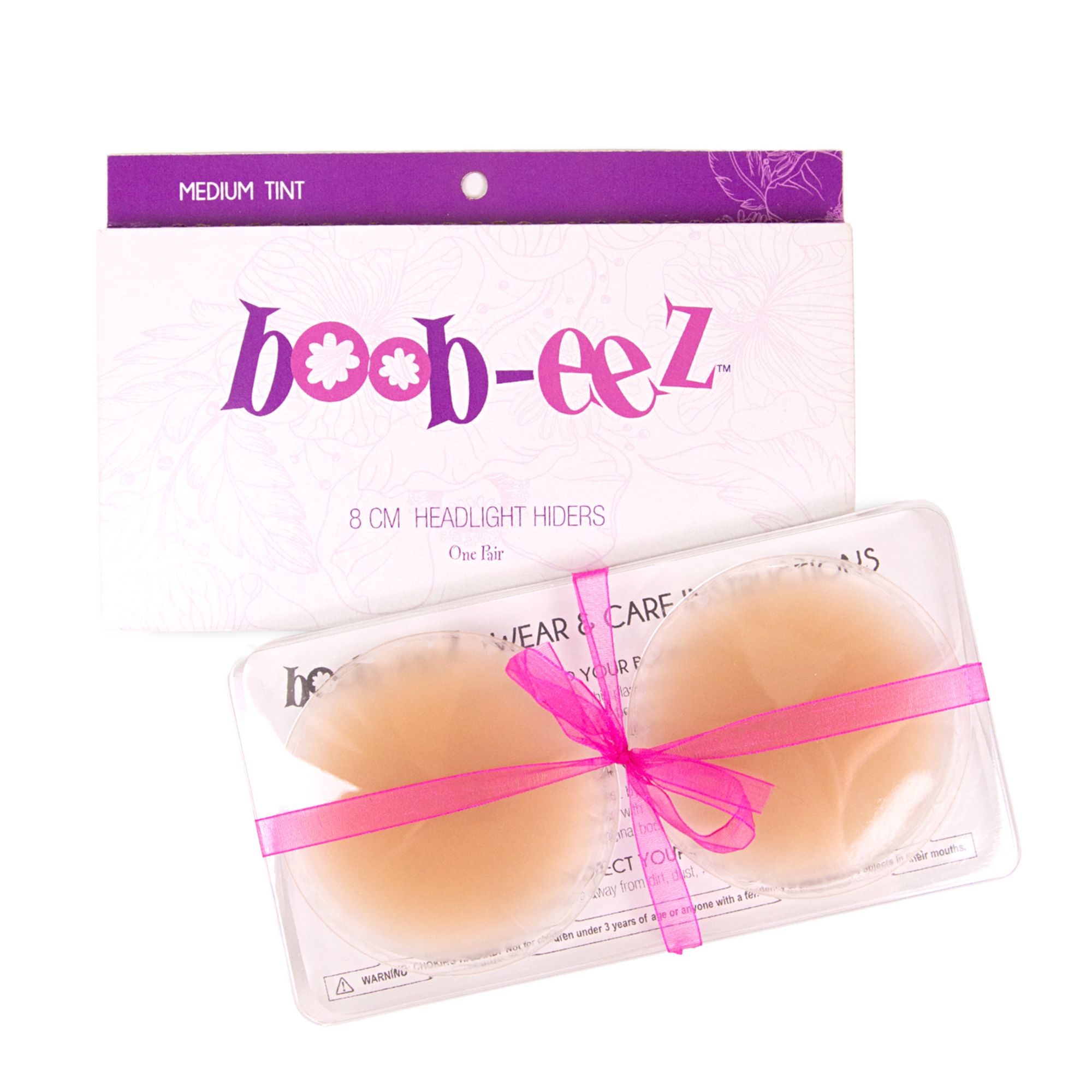 Product shot of reusable 8cm Medium tint Headlight Hiders in recycled craft packaging and informative insert card with wear and care instructions and Boob-eez brand story