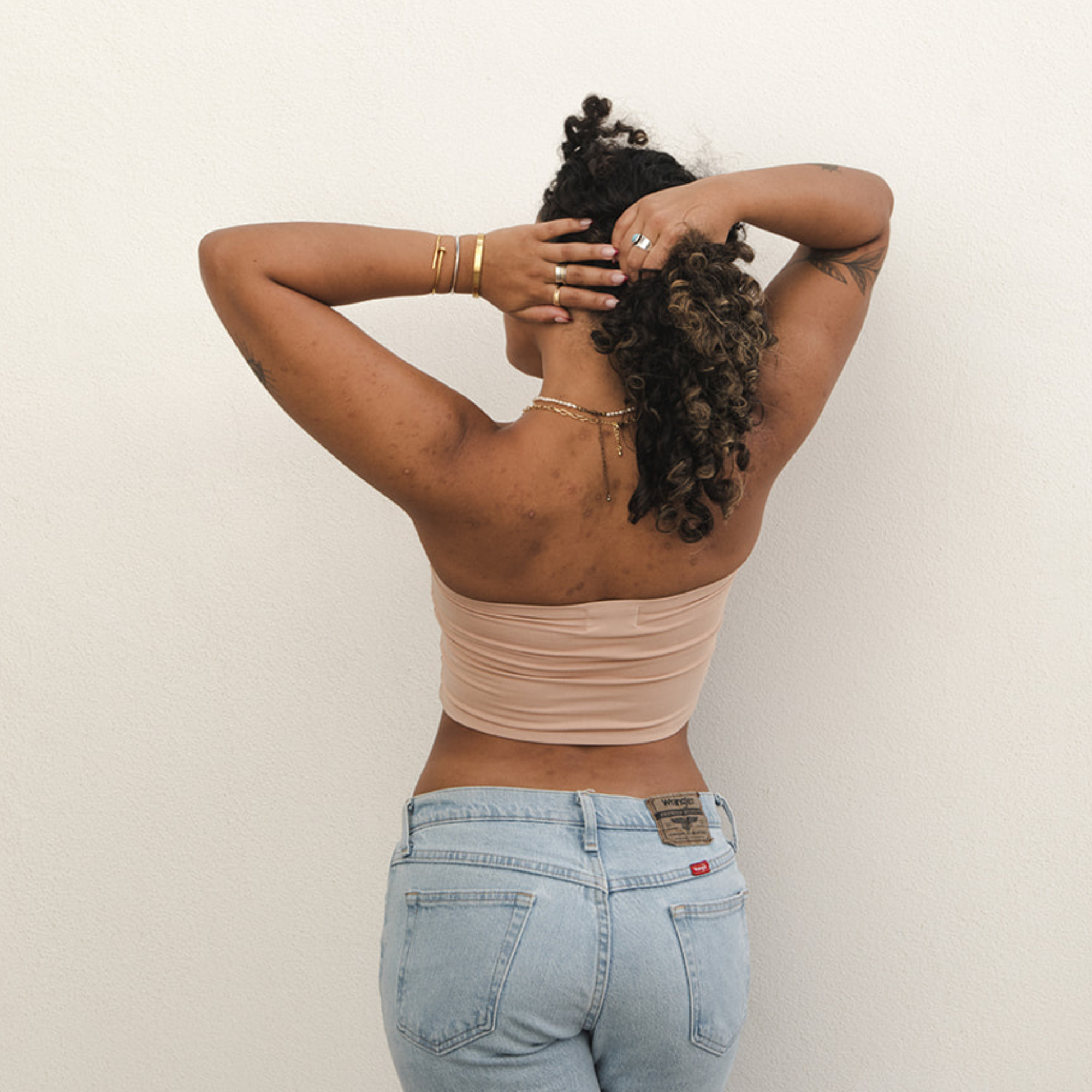 Product shot of NŪD Apparel Hunter Double-Layered Bandeau, strapless, cropped and seamless style, made of bamboo fabric produced in California, in Light Nude on medium-skinned model paired with light-wash jeans, back shot