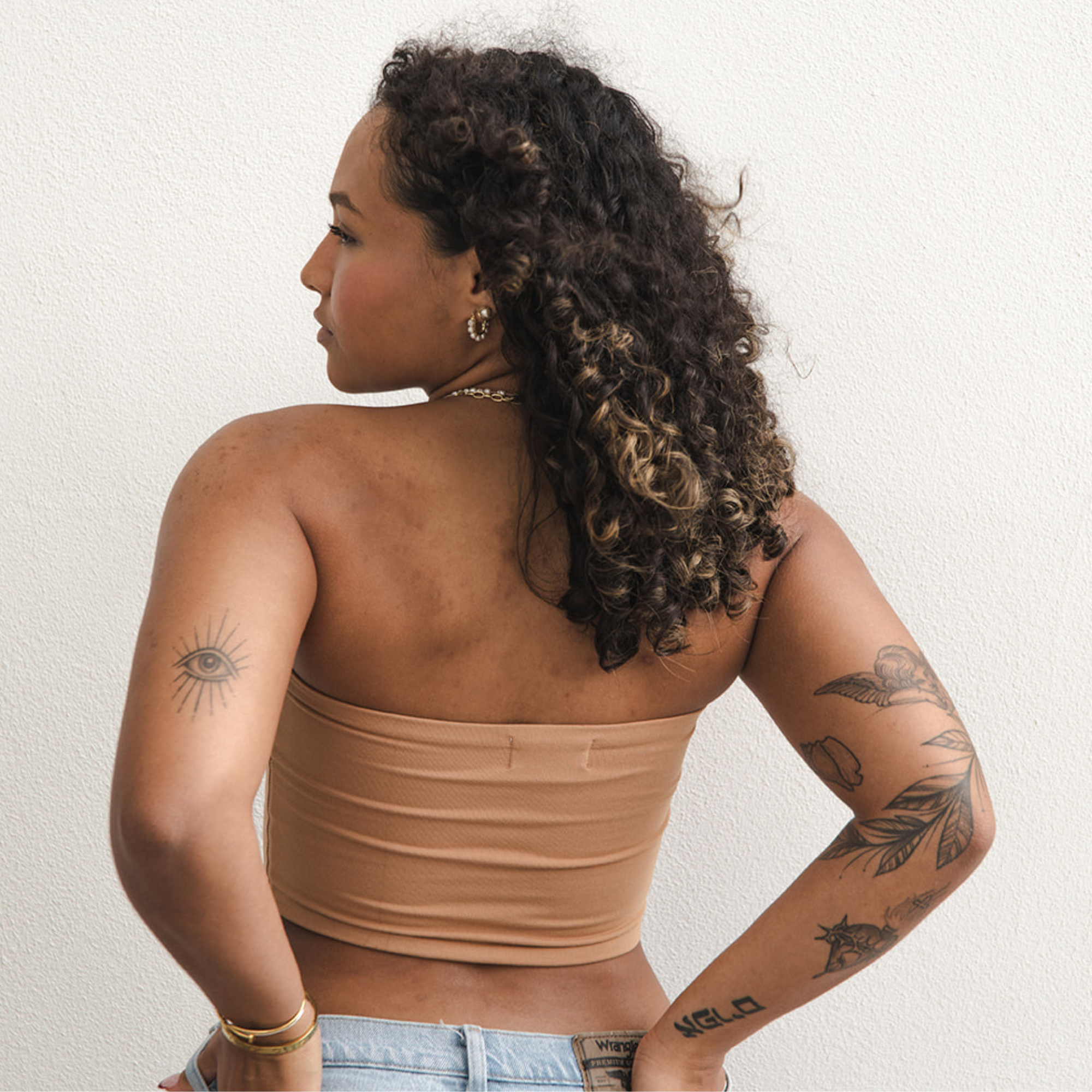 Product shot of NŪD Apparel Hunter Double-Layered Bandeau, strapless, cropped and seamless style, made of bamboo fabric produced in California, in Medium Nude on medium-skinned model paired with light-wash jeans, back shot