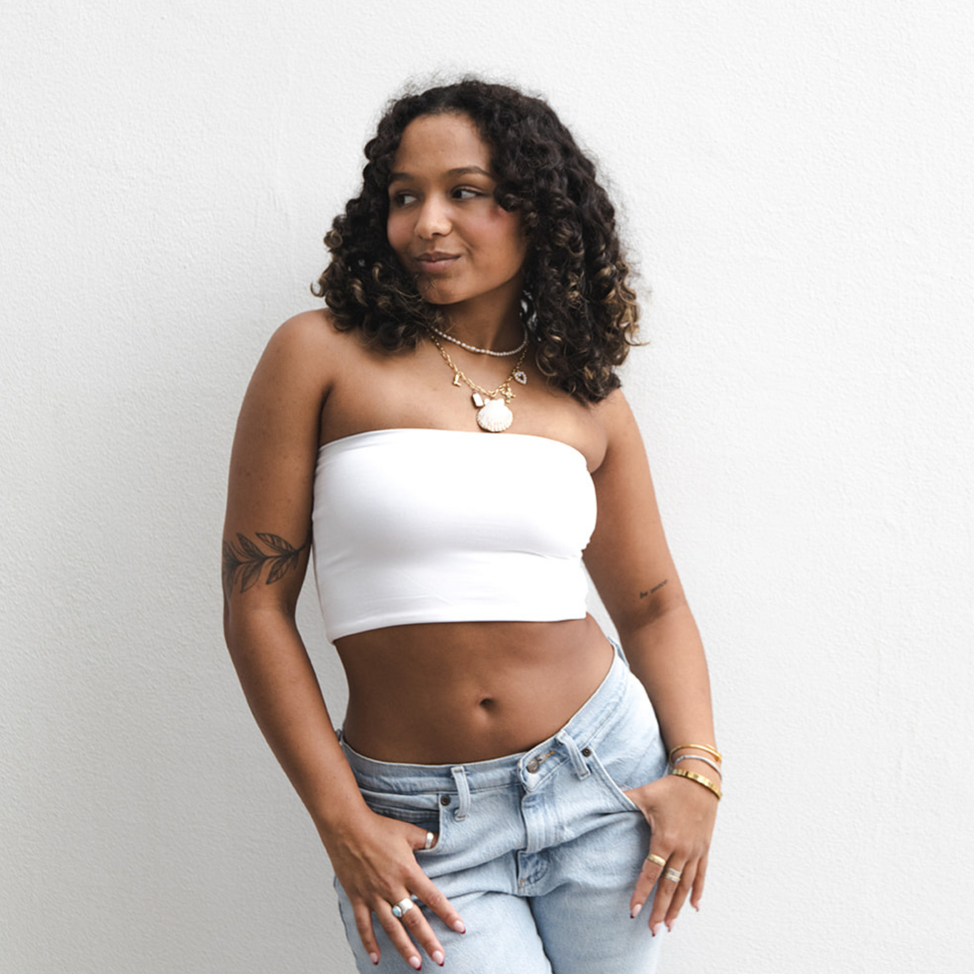 Product shot of NŪD Apparel Hunter Double-Layered Bandeau, strapless, cropped and seamless style, made of bamboo fabric produced in California, in White on medium-skinned model paired with light-wash jeans, front shot