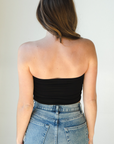 Product shot of NŪD Apparel Hunter Double-Layered Bandeau, strapless, cropped and seamless style, made of bamboo fabric produced in California, in Black on fair-skinned model paired with medium-wash jeans, back shot