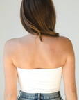 Product shot of NŪD Apparel Hunter Double-Layered Bandeau, strapless, cropped and seamless style, made of bamboo fabric produced in California, in White on fair-skinned model paired with medium-wash jeans, back shot