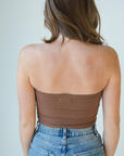 Product shot of NŪD Apparel Hunter Double-Layered Bandeau, strapless, cropped and seamless style, made of bamboo fabric produced in California, in Dark Nude on fair-skinned model paired with medium-wash jeans, back shot