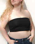 Product shot of NŪD Apparel Hunter Double-Layered Bandeau, strapless, cropped and seamless style, made of bamboo fabric produced in California, in Black on fair-skinned model paired with dark-wash jeans, front shot