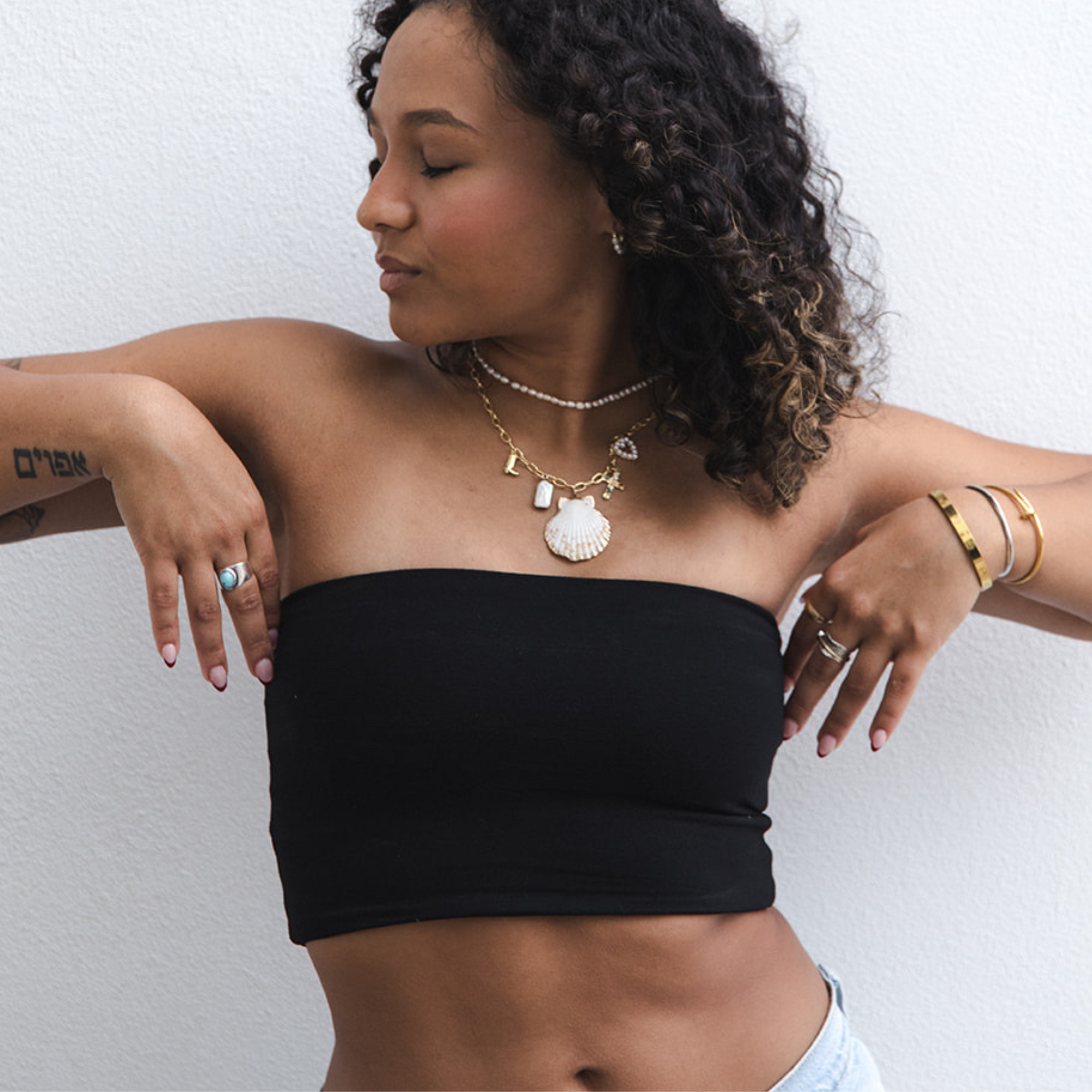 Product shot of NŪD Apparel Hunter Double-Layered Bandeau, strapless, cropped and seamless style, made of bamboo fabric produced in California, in Black on medium-skinned model paired with light-wash jeans, front shot