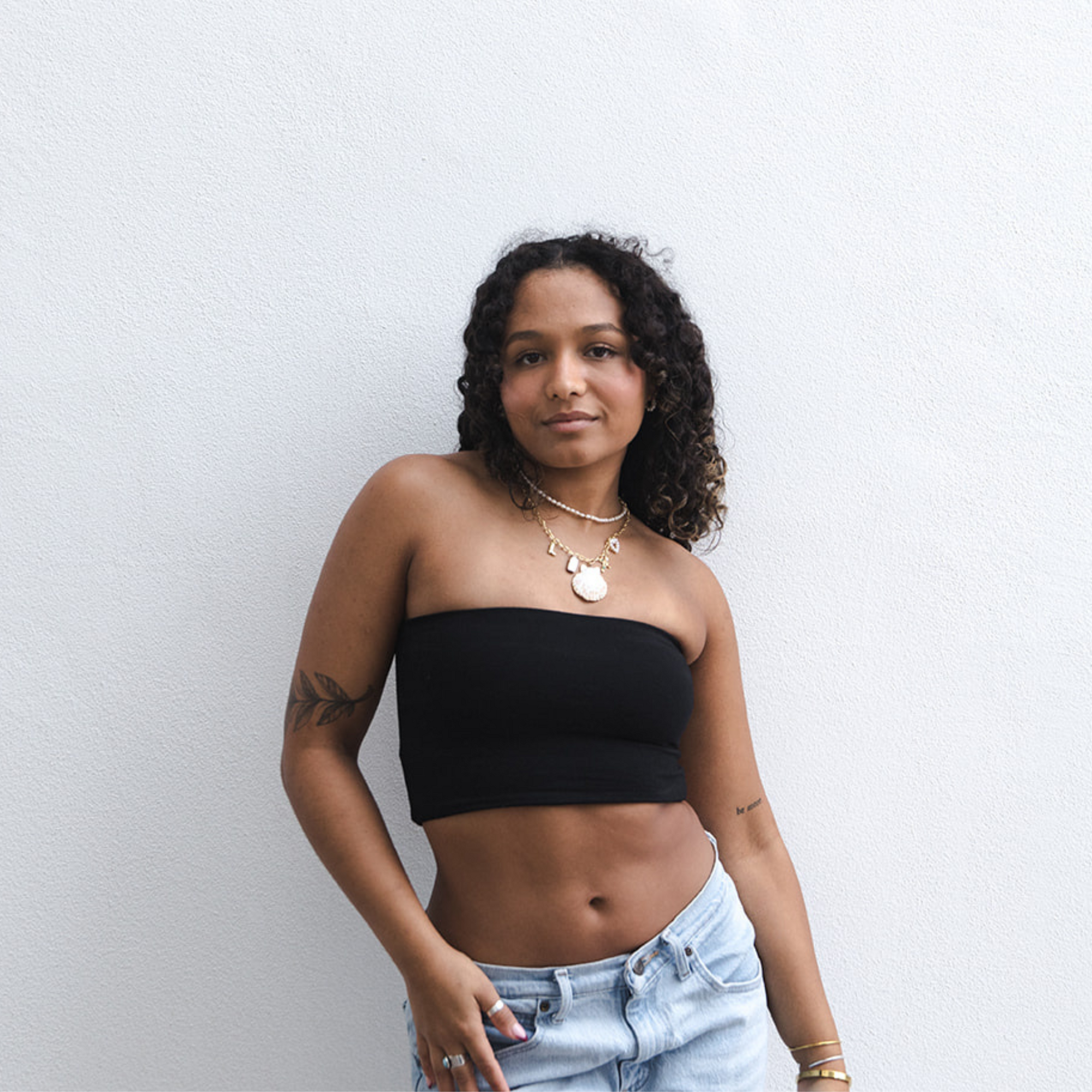Product shot of NŪD Apparel Hunter Double-Layered Bandeau, strapless, cropped and seamless style, made of bamboo fabric produced in California, in Black on medium-skinned model paired with light-wash jeans, front shot