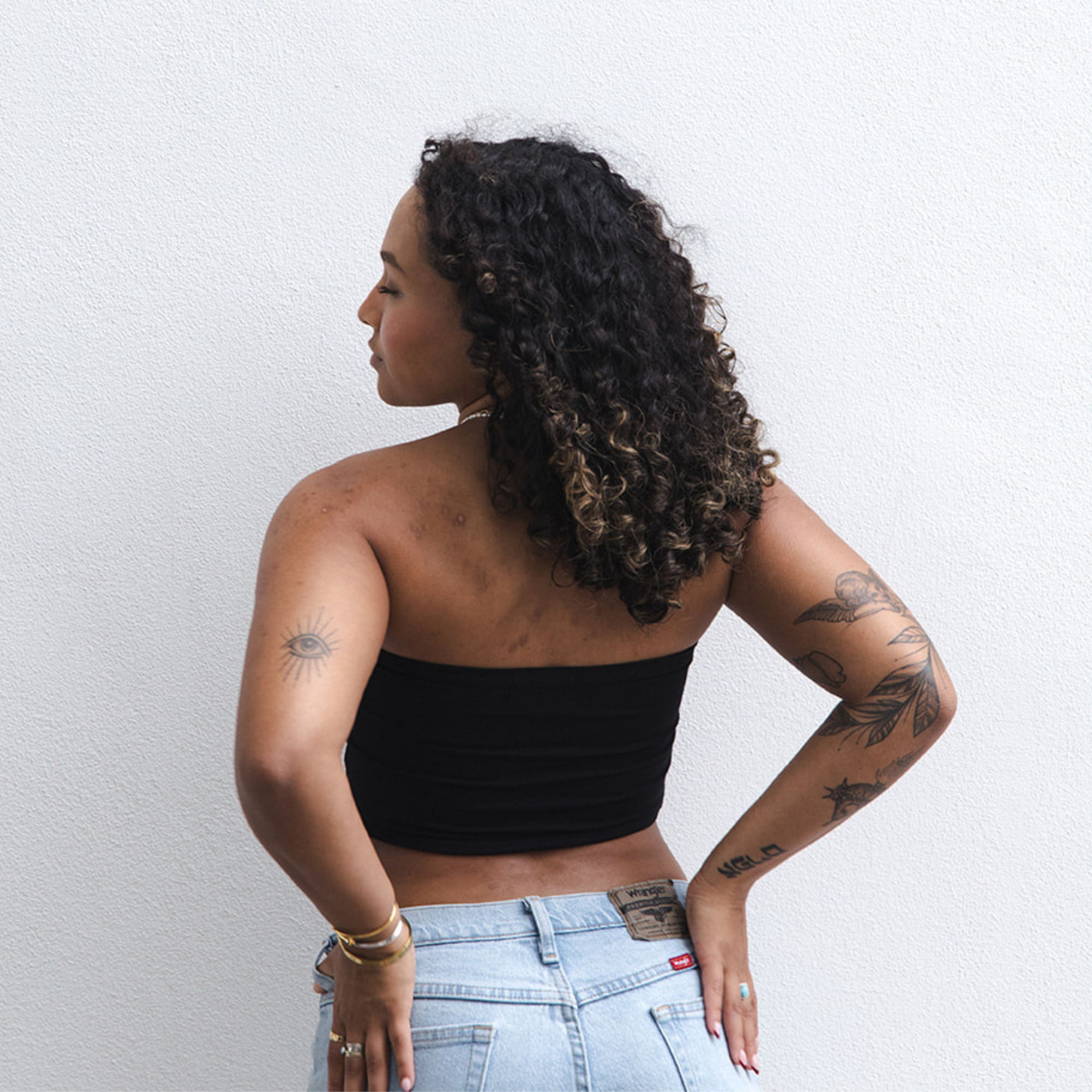 Product shot of NŪD Apparel Hunter Double-Layered Bandeau, strapless, cropped and seamless style, made of bamboo fabric produced in California, in Black on medium-skinned model paired with light-wash jeans, back shot