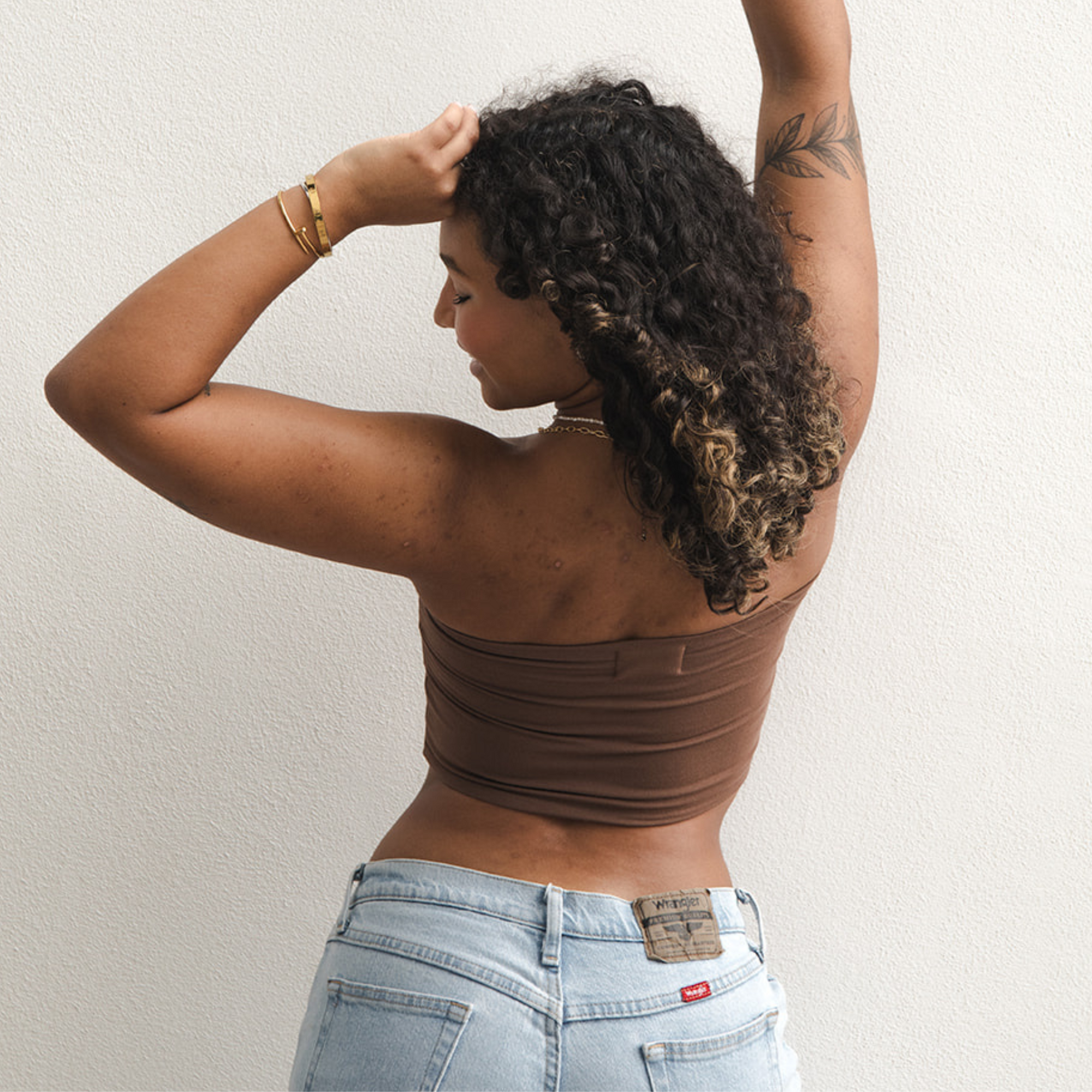 Product shot of NŪD Apparel Hunter Double-Layered Bandeau, strapless, cropped and seamless style, made of bamboo fabric produced in California, in Dark Nude on medium-skinned model paired with light-wash jeans, back shot
