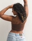 Product shot of NŪD Apparel Hunter Double-Layered Bandeau, strapless, cropped and seamless style, made of bamboo fabric produced in California, in Dark Nude on medium-skinned model paired with light-wash jeans, back shot