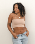 Product shot of NŪD Apparel Hunter Double-Layered Bandeau, strapless, cropped and seamless style, made of bamboo fabric produced in California, in Light Nude on medium-skinned model paired with light-wash jeans