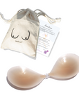 Product shot of a reusable and sticky Light tint Silicone Stick-on Bra with Boob-eez branded drawstring unbleached cotton muslin pouch and information insert card with wear and care instructions against a white background, showing the thin edges of the Silicone tick-on Bra