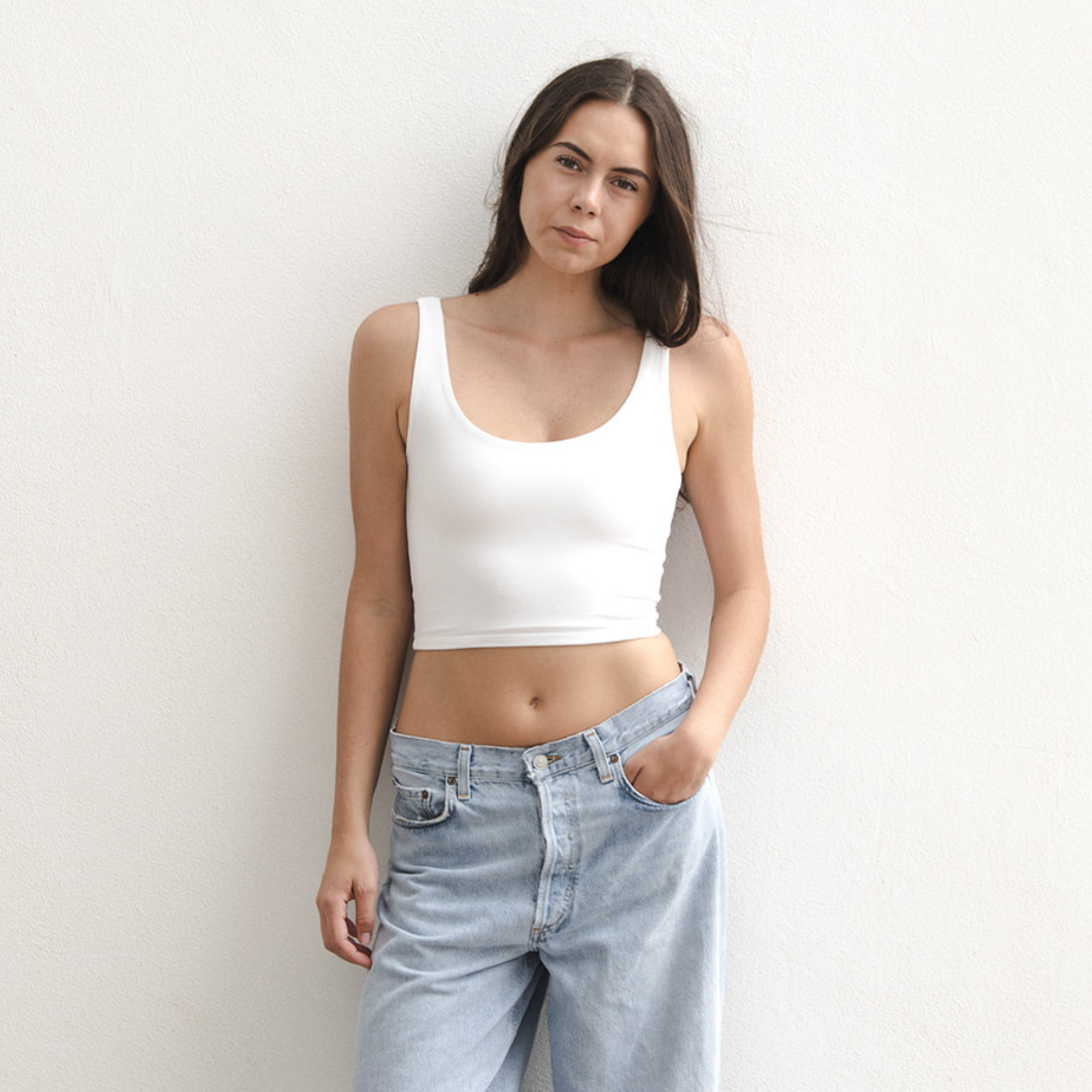Product shot of NŪD Apparel Devon Double Layered Scoop Crop top, wide strap and seamless, made of bamboo fabric produced in California, in White on fair-skinned model paired with light-wash jeans, front shot