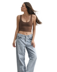 Product shot of NŪD Apparel Devon Double Layered Scoop Crop top, wide strap and seamless, made of bamboo fabric produced in California, in Dark Nude on fair-skinned model paired with light-wash jeans, front wide shot