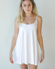 Product shot of NŪD Apparel Betty Swinging Slip Dress, thin adjustable strap, loose style and with shelf bra, made of bamboo fabric produced in California, in White on fair-skinned model, front shot