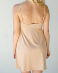 Product shot of NŪD Apparel Betty Swinging Slip Dress, thin adjustable strap, loose style and with shelf bra, made of bamboo fabric produced in California, in Light Nude on fair-skinned model, back shot