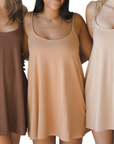 Product shot of NŪD Apparel Betty Swinging Slip Dress, thin adjustable strap, loose style and with shelf bra, made of bamboo fabric produced in California, in Dark Nude on fair-skinned model, in Medium Nude on medium-skinned model, and in Light Nude on fair-skinned model, front shot