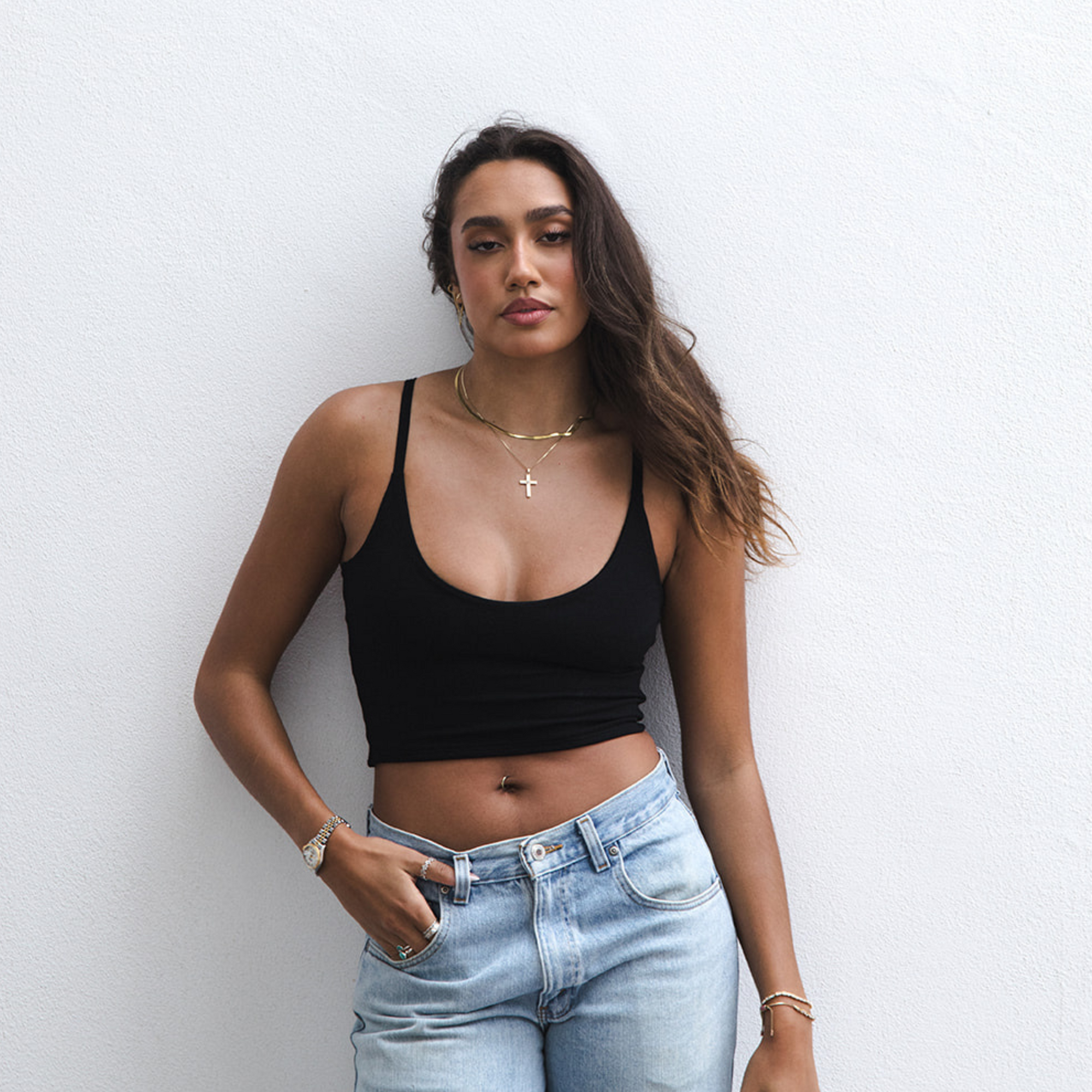 Product shot of NŪD Apparel Kyla Double Layered Crop top, thin strap and seamless, made of bamboo fabric produced in California, in Black on medium-skinned model paired with light-wash jeans, front shot