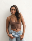 Product shot of NŪD Apparel Kyla Double Layered Crop top, thin strap and seamless, made of bamboo fabric produced in California, in Dark Nude on medium-skinned model paired with light-wash jeans, front shot