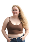 Product shot of NŪD Apparel Kyla Double Layered Crop top, thin strap and seamless, made of bamboo fabric produced in California, in Dark Nude on fair-skinned model paired with dark-wash jeans, front shot