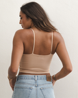 Product shot of NŪD Apparel Kyla Double Layered Crop top, thin strap and seamless, made of bamboo fabric produced in California, in Light Nude on medium-skinned model paired with light-wash jeans, back shot