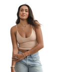 Product shot of NŪD Apparel Kyla Double Layered Crop top, thin strap and seamless, made of bamboo fabric produced in California, in Light Nude on medium-skinned model paired with light-wash jeans, front shot