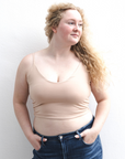 Product shot of NŪD Apparel Kyla Double Layered Crop top, thin strap and seamless, made of bamboo fabric produced in California, in Light Nude on fair-skinned model paired with dark-wash jeans, front shot