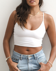 Product shot of NŪD Apparel Kyla Double Layered Crop top, thin strap and seamless, made of bamboo fabric produced in California, in White on medium-skinned model paired with light-wash jeans, front shot