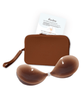 Product shot of sticky Dark tint Silicone Stick-on Bra and durable Silicone Travel Case for Stick-on Bras in Dark Nude and information card with wear and care instructions, against a white background showing the thin edges of the Silicone Stick-on Bra