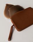 Product shot of our stick Silicone Stick-on Bra and our durable Silicone Travel Case for the Silicone Stick-on Bra in Dark Nude, close-up shot showing the Boob-eez branded case and removable strap