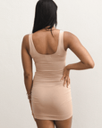 Product shot of NŪD Apparel Tayler Slip Dress, wide strap, fitted style and seamless, made of bamboo fabric produced in California, in Light Nude on medium-skinned model, back shot