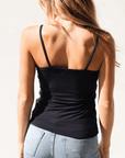 Product shot of NŪD Apparel Nesha Double Layered Tank, thin strap, long style and seamless, made of bamboo fabric produced in California, in Black on fair-skinned model paired with light-wash jeans, back shot