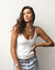 Product shot of NŪD Apparel Nesha Double Layered Tank, thin strap, long style and seamless, made of bamboo fabric produced in California, in White on medium-skinned model paired with light-wash jeans, front shot