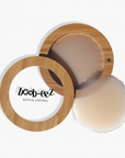 Product shot of Boob-eez Bamboo Compact with 8cm Light tint Headlight Hiders inside and informative insert cards with wear and care instructions, close-up shot showing how to open and close the Bamboo Compact