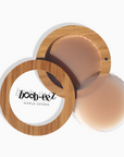 Product shot of Boob-eez Bamboo Compact with 8cm Medium tint Headlight Hiders inside and informative insert cards with wear and care instructions, close-up shot showing how to open and close the Bamboo Compact