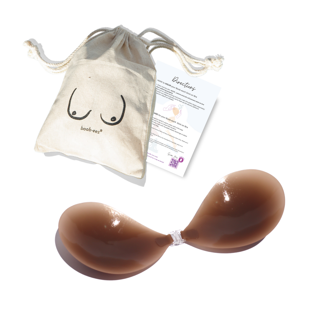 Product shot of a sticky Dark tint Silicone Stick-on Bra with a branded drawstring unbleached cotton muslin pouch and information insert card with wear and care instructions, close-up shot of clasp and thin edge of the Silicone Stick-on Bra