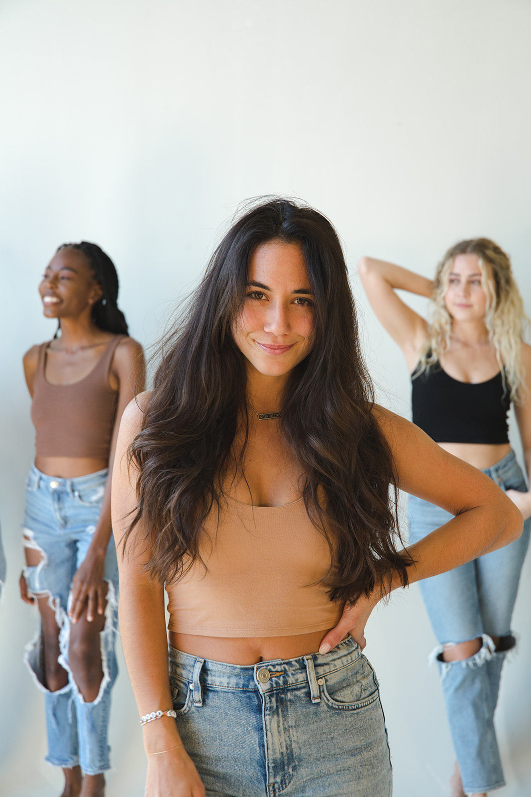 Three women wearing Boob-eez under fitted tanks and denim