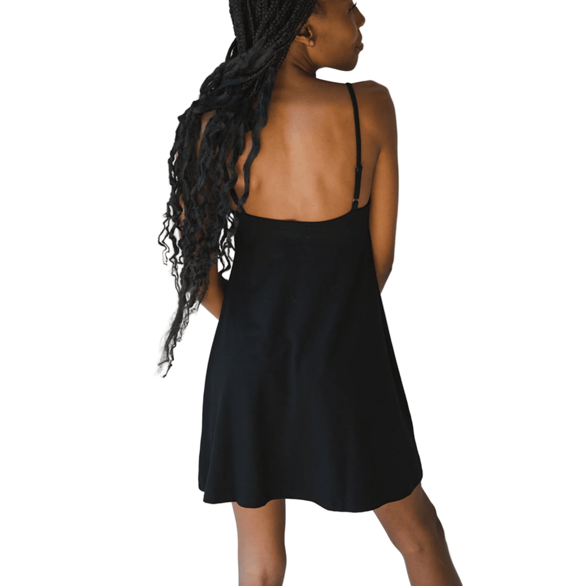 Product shot of NŪD Apparel Betty Swinging Slip Dress, thin adjustable strap, loose style and with shelf bra, made of bamboo fabric produced in California, in Black on dark-skinned model, back shot