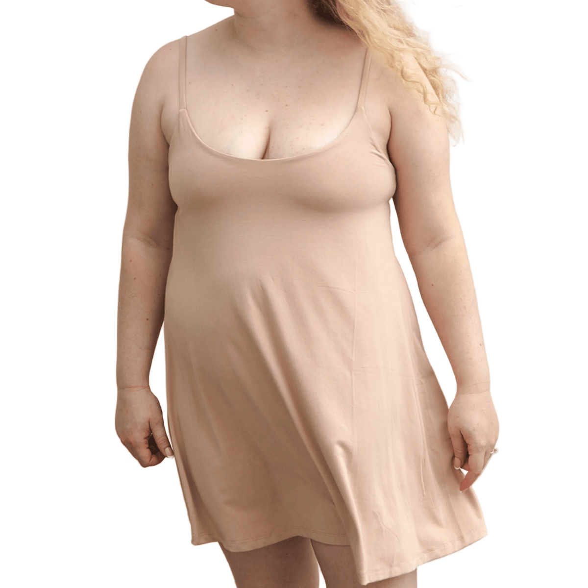 Product shot of NŪD Apparel Betty Swinging Slip Dress, thin adjustable strap, loose style and with shelf bra, made of bamboo fabric produced in California, in Light Nude on fair-skinned model, front shot