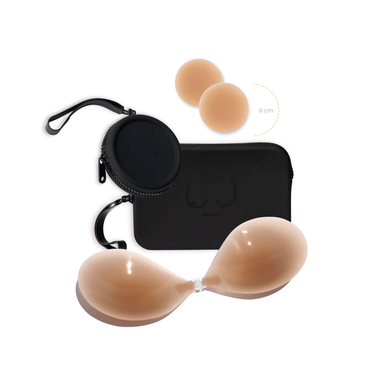 Product shot of a sticky Medium tint 6cm Headlight Hiders and Silicone Stick-on Bra with a durable Silicone Travel Cases in Black and informative insert card with wear and care instructions, close-up front shot showing the Boob-eez branded Silicone Travel Case with a zipper detail and removable strap