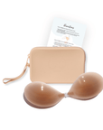 Product shot of sticky Medium tint Silicone Stick-on Bra and durable Silicone Travel Case for Silicone Stick-on Bras in Light Nude and information insert card with wear and care instructions, against a white background showing the thin edges of the Silicone Stick-on Bra