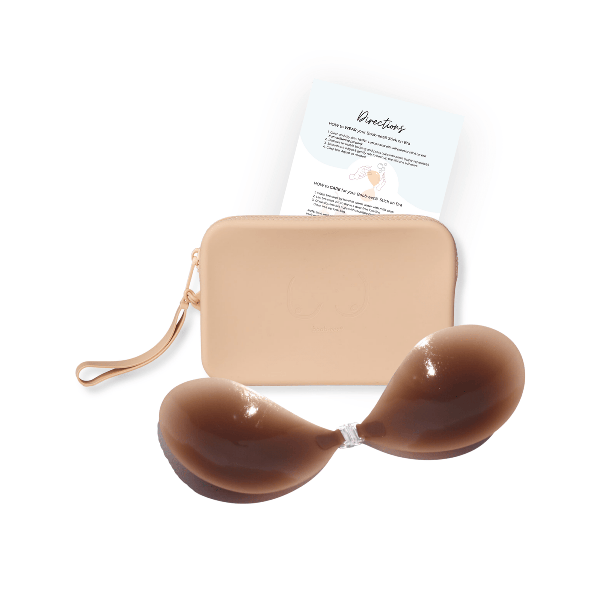Product shot of sticky Dark tint Silicone Stick-on Bra and durable Silicone Travel Case for Silicone Stick-on Bras in Light Nude and information insert card with wear and care instructions, against a white background showing the thin edges of the Silicone Stick-on Bra