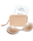 Product shot of sticky Light tint Silicone Stick-on Bra and durable Silicone Travel Case for Silicone Stick-on Bras in Light Nude and information insert card with wear and care instructions, against a white background showing the thin edges of the Silicone Stick-on Bra