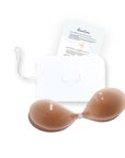 Product shot of sticky Medium tint Silicone Stick-on Bra and durable Silicone Travel Case for Silicone Stick-on Bras in White and information insert card with wear and care instructions, against a white background showing the thin edges of the Silicone Stick-on Bra