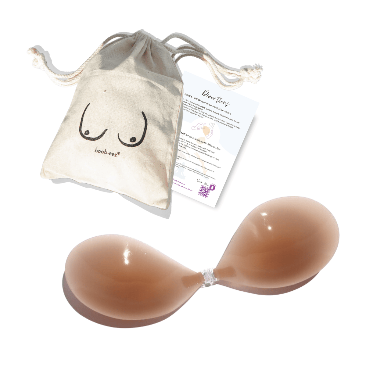 Product shot of reusable and sticky Medium Tint Silicone Stick-on Bra with a branded drawstring unbleached cotton muslin pouch packaging and information insert card with wear and care instructions, showing thin edge of the Silicone Stick-on Bra
