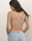 Product shot of NŪD Apparel Devon Double Layered Scoop Crop top, wide strap and seamless, made of bamboo fabric produced in California, in Light Nude on fair-skinned model paired with light-wash jeans, back shot