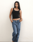 Product shot NŪD Apparel Devon Long Double Layer Scoop, wide strap, perfect length and seamless, made of bamboo fabric produced in California, in Black on medium-skinned model paired with dark-wash jeans, front wide shot