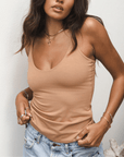Product shot of NŪD Apparel Nesha Double Layered Tank, thin strap, long style and seamless, made of bamboo fabric produced in California, in Medium Nude on medium-skinned model paired with light-wash jeans, front shot