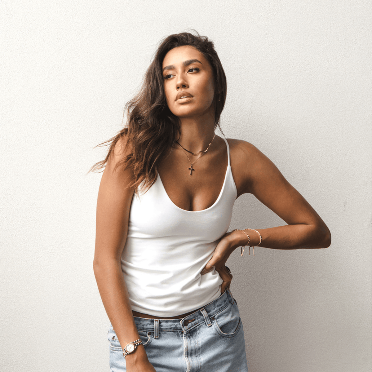 Product shot of NŪD Apparel Nesha Double Layered Tank, thin strap, long style and seamless, made of bamboo fabric produced in California, in White on medium-skinned model paired with light-wash jeans, front shot