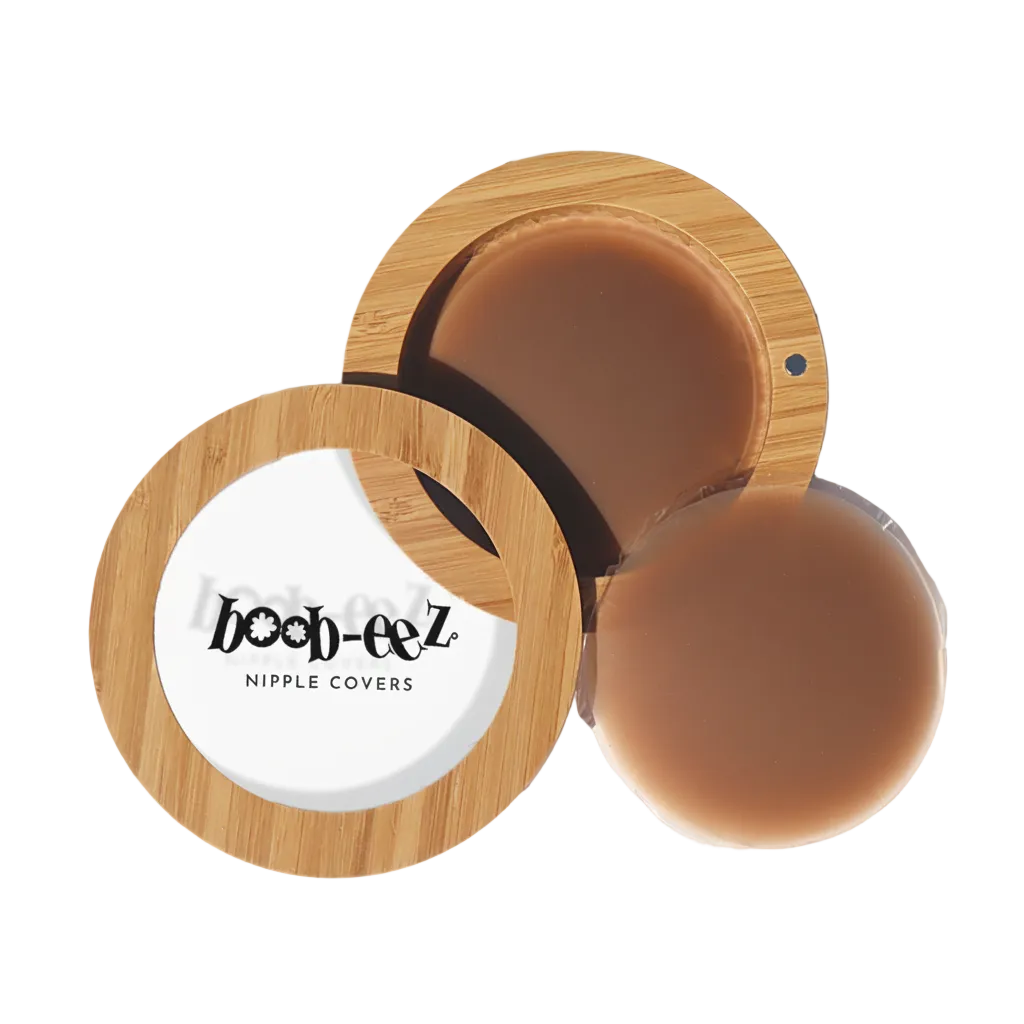 Product shot of Boob-eez Bamboo Compact with 8cm Dark tint Headlight Hiders inside and informative insert cards with wear and care instructions, close-up shot showing how to open and close the Bamboo Compact
